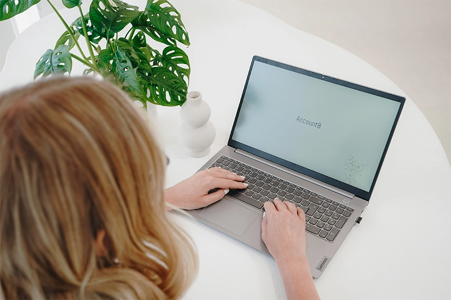 Person using a laptop with Account8 wallpaper