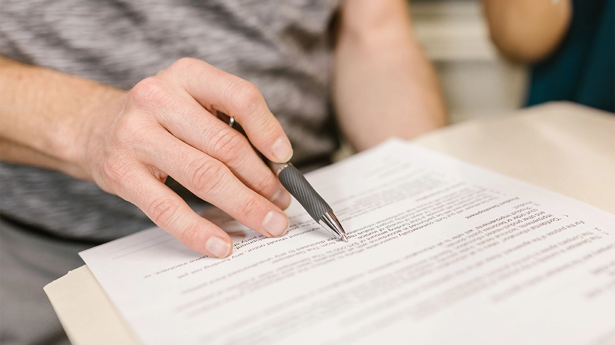 Business owner reading through document while holding pen