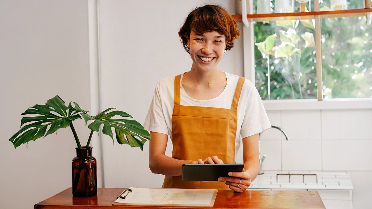 Young business owner holding tablet and smiling at camera
